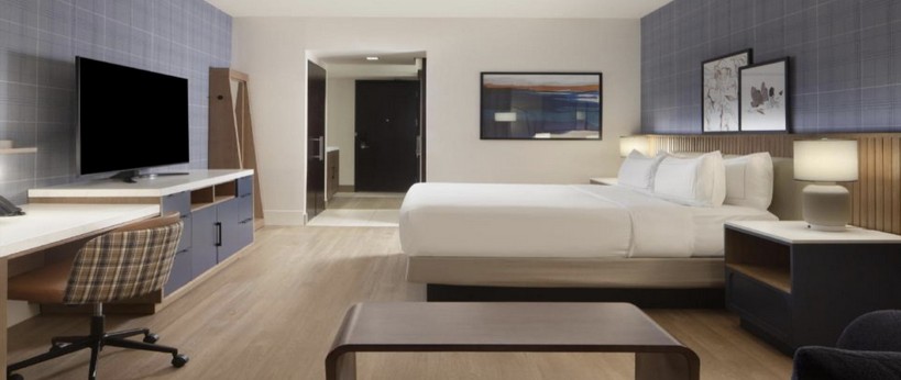 Hilton Granite Park guestroom with light wood casegoods and work desk